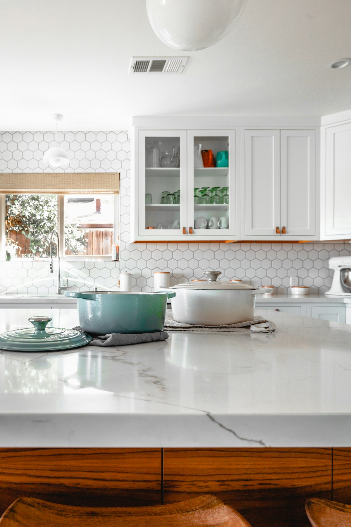 A clean kitchen counter with cookware and wooden utensils